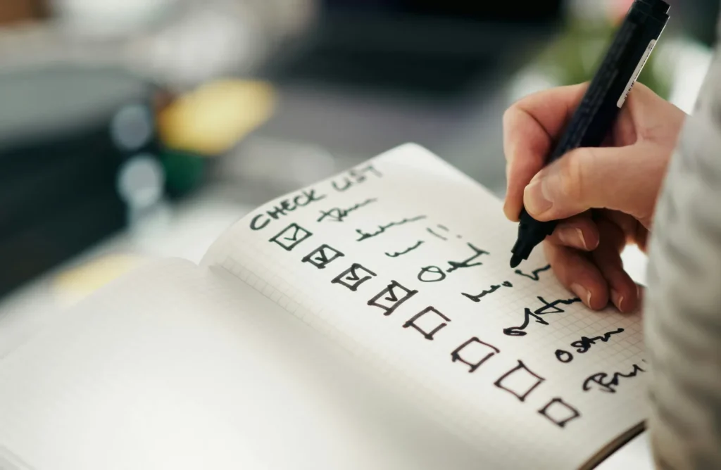 Hand ticking a checklist in a notebook