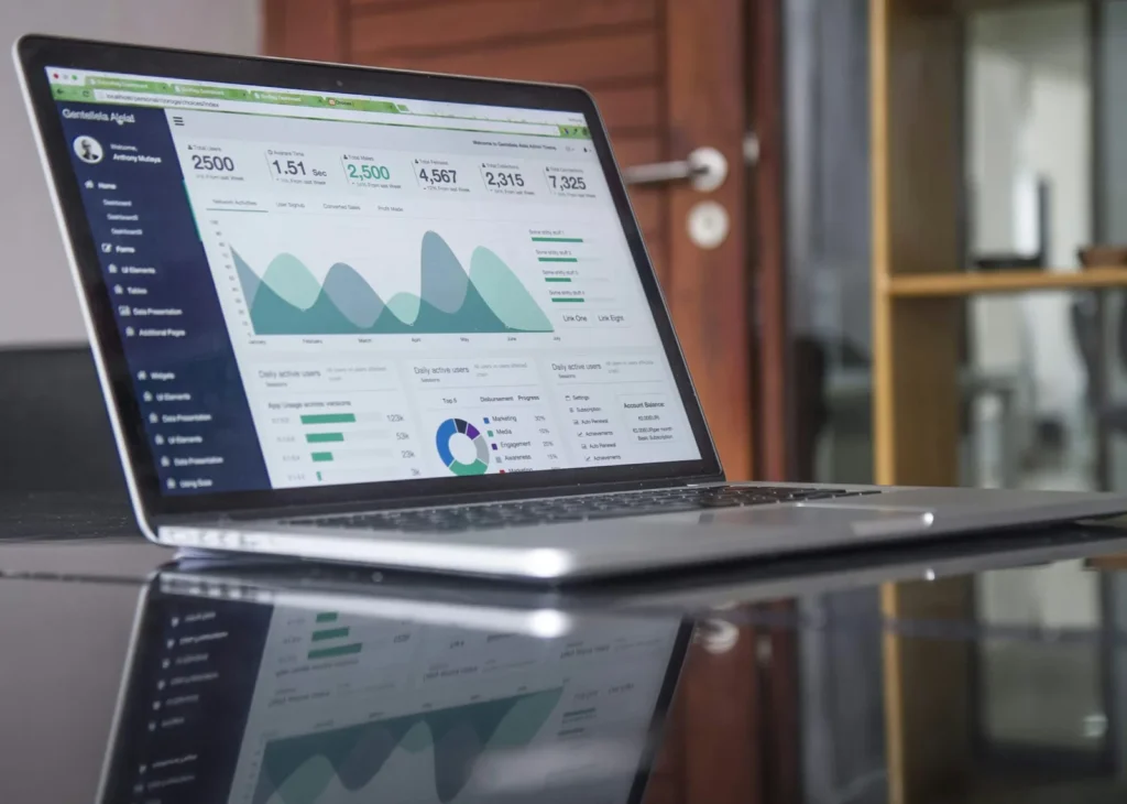 Laptop showing charts and metrics on a desk