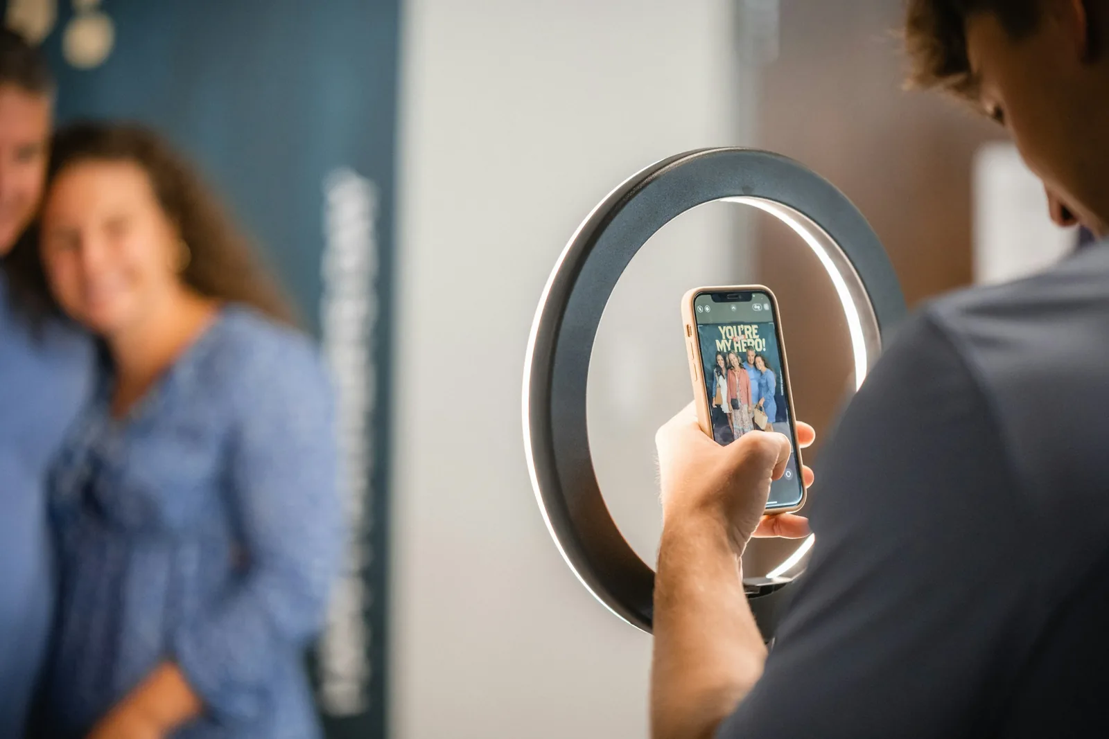 Two people filming a phone video with a ring light