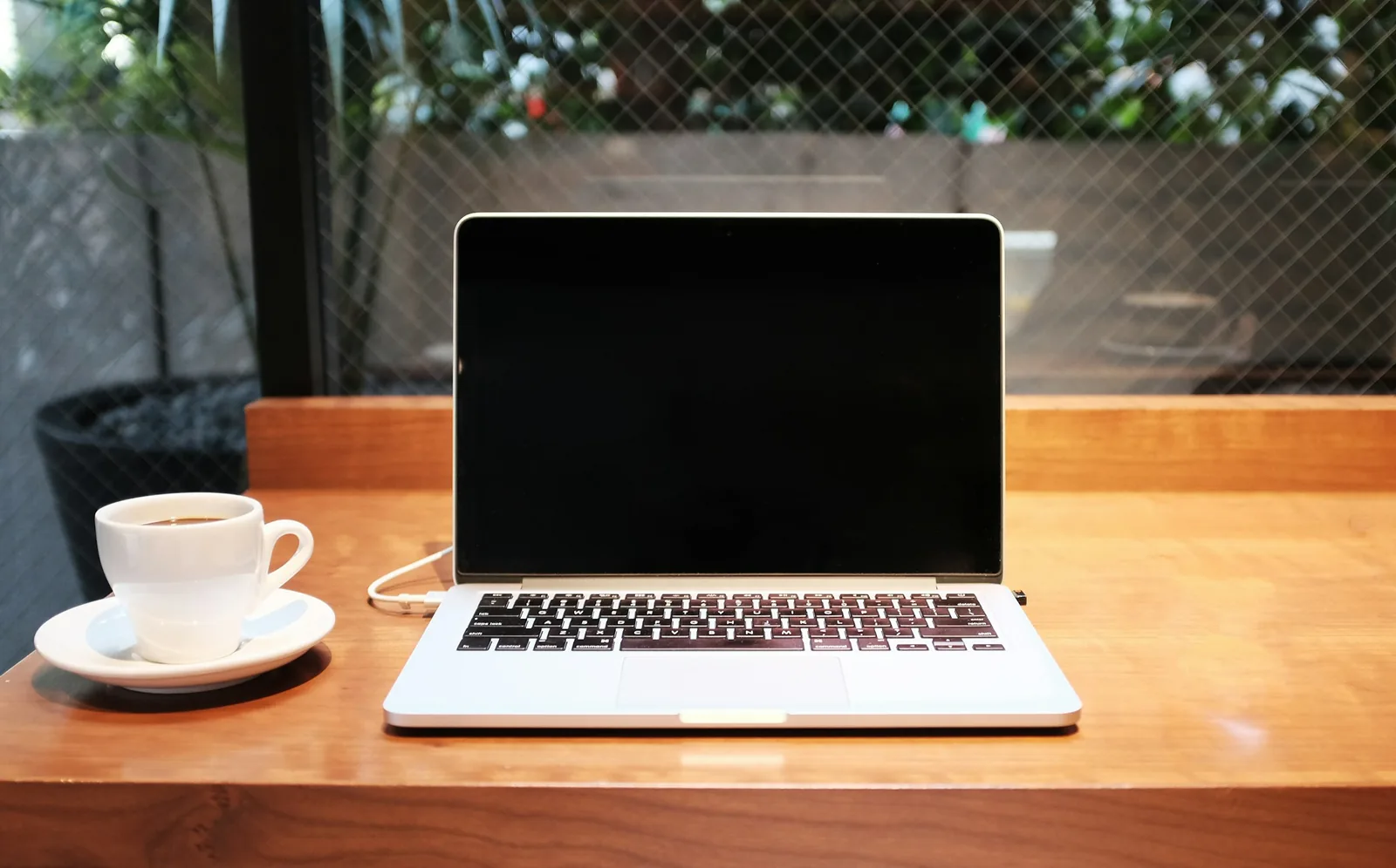 Laptop and coffee mug on a wooden desk